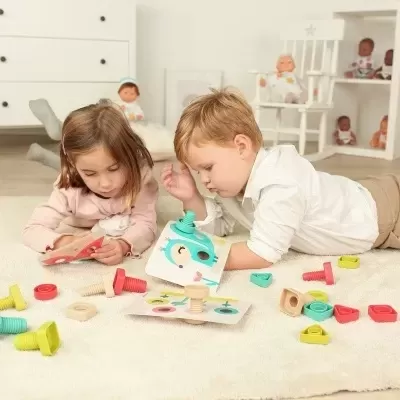 Crianças a brincar com jogo de construção de madeira colorida no chão