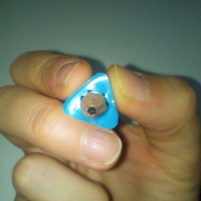 Lápis triangular azul numa mão com ponta por afiar