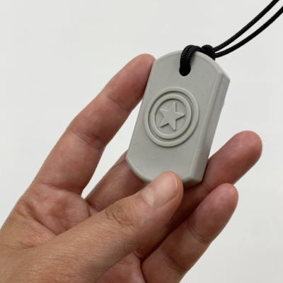 Pendente cinzento claro com estrela em relevo segurado pela mão