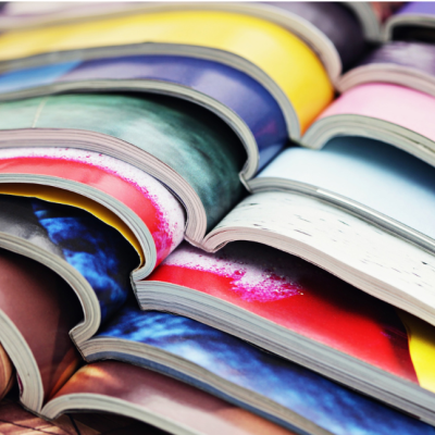 Pilhas de livros e revistas com capas coloridas e páginas expostas