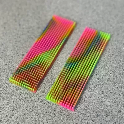 Painéis retangulares com pequenos pinos de plástico coloridos sobre superfície cinzenta