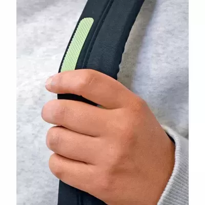 Mão segurando alça de mochila acolchoada preta com detalhe verde