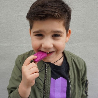 Menino a segurar um objeto rosa pendurado num cordão preto