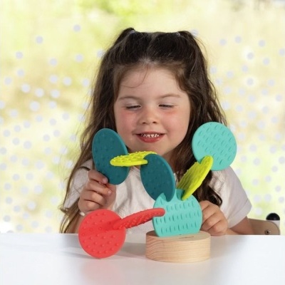 Brinquedo colorido de silicone com suporte em madeira na mesa