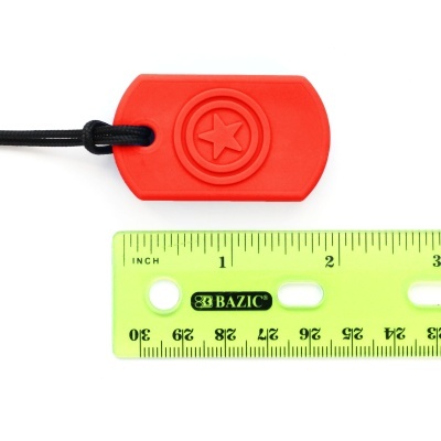 Etiqueta vermelha com estrela num cordão preto ao lado de uma régua verde BAZIC