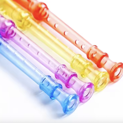 Conjunto de quatro flautas de plástico coloridas sobre fundo branco