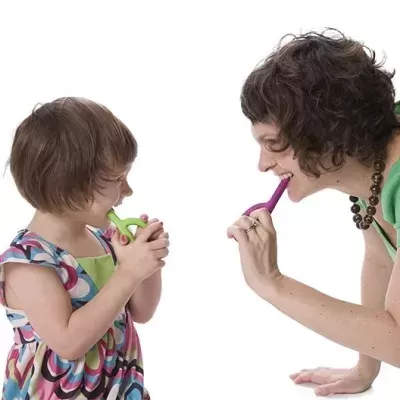 Criança e mulher a escovar os dentes com escovas coloridas em fundo branco