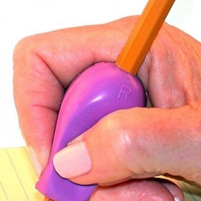 Mão segurando lápis com apoio de plástico roxo a escrever numa folha amarela riscada