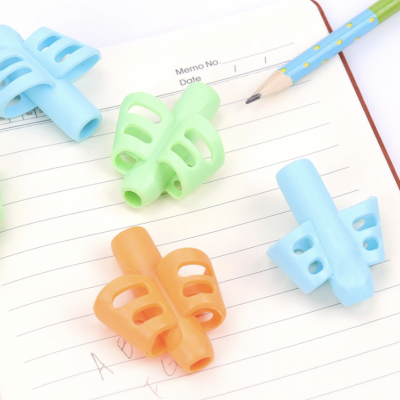 Apontadores de lápis em diferentes cores sobre um caderno aberto e um lápis azul