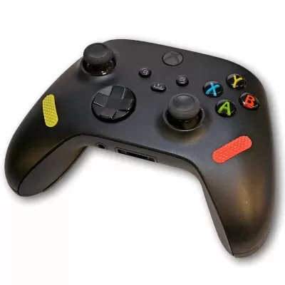 Comando Xbox preto com botões coloridos e autocolantes amarelo e vermelho