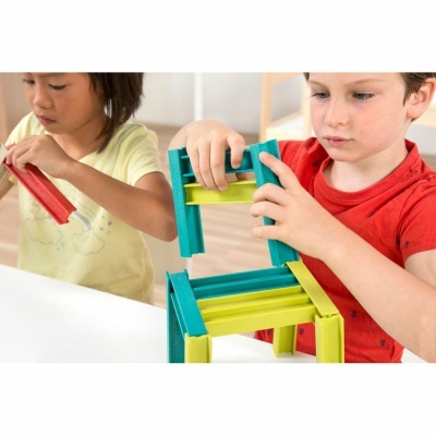 Crianças a montar cadeira colorida de peças de plástico.