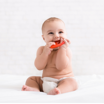 Bebé em fralda com brinquedo vermelho