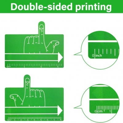 Régua verde com desenho de mão e medidas em polegadas e centímetros