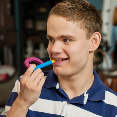 Jovem usando dispositivo de ajuda para alimentação, camisa polo às riscas