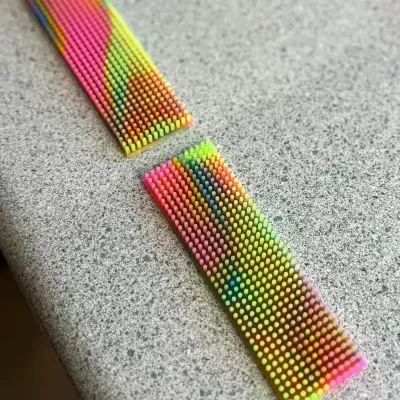 Duas réguas coloridas neon sobre superfície cinza granulado