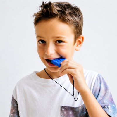 Camisola branca com padrão galáctico nas mangas, menino a morder objeto azul pendurado num colar