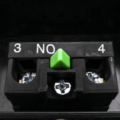 Componente elétrico preto com botão verde e parafusos