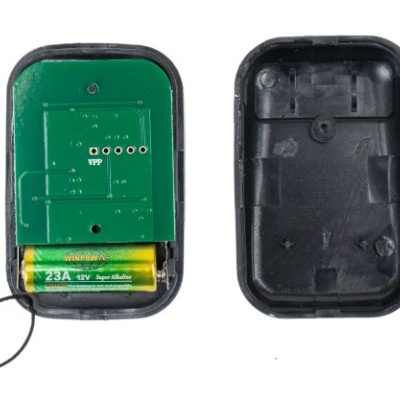 Comando remoto preto aberto com placa eletrónica e pilha visível