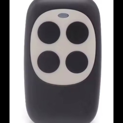 Comando à distância preto com quatro botões circulares sobre painel branco