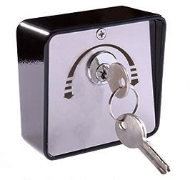 Fechadura quadrada metálica prateada e preta com chave inserida