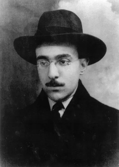 Black and white portrait of man wearing wide-brimmed hat and glasses