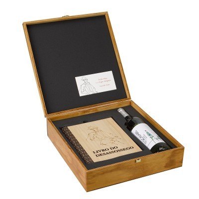 Caixa de madeira aberta com livro e garrafa de vinho