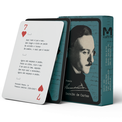 Baralho de cartas com caixa azul-esverdeada e preto com retrato de homem e carta 7 de copas com poema em português