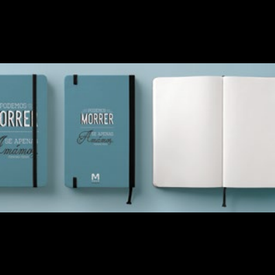 Caderno azul com elástico preto e texto na capa, e caderno aberto com páginas em branco.