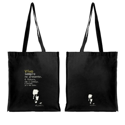 Saco de pano preto com frase em branco e amarelo e rosto masculino impresso na parte inferior
