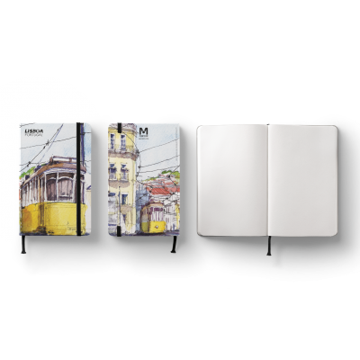 Três cadernos Moleskine, dois com capas ilustradas de elétricos amarelos em Lisboa e um aberto com páginas brancas.