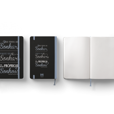 Três cadernos pretos para escrever, dois fechados com texto em branco e um aberto mostrando páginas em branco