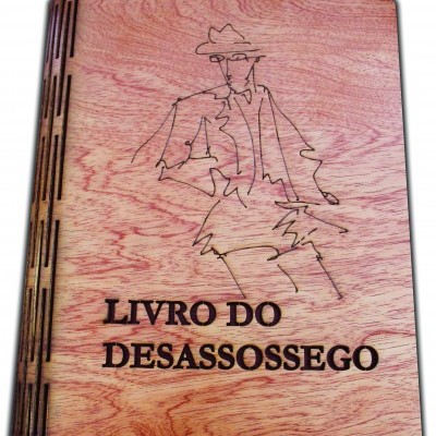 Livro de capa de madeira clara com desenho linear e texto 'LIVRO DO DESASSOSSEGO'