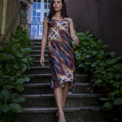 Mulher a usar vestido midi com padrão animal print a descer escadas exteriores