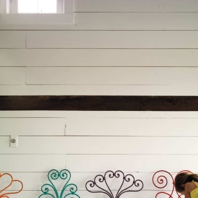 Cadeiras metálicas coloridas com design arabesco contra parede branca