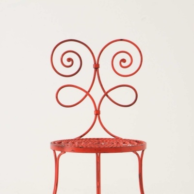 Cadeira vermelha de metal com design em espiral e assento redondo em malha