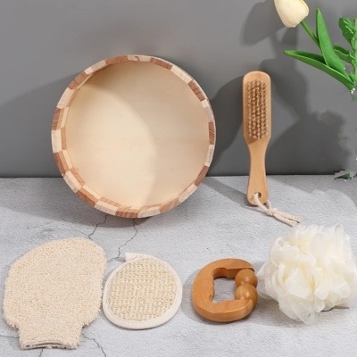 Conjunto de acessórios de banho em madeira e fibras naturais, incluindo bacia, escova, esponja, luva e massageador.