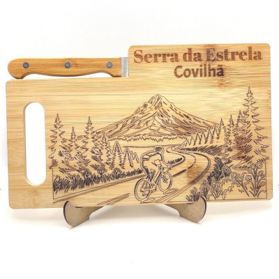 Tábua de cortar em madeira com gravura de ciclista e montanhas e texto Serra da Estrela Covilhã