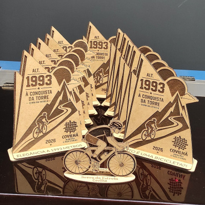 Conjunto de troféus de madeira com motivo de ciclista e montanha, texto sobre Serra da Estrela e Covilhã