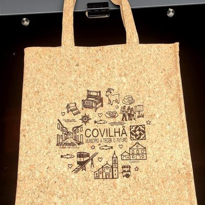 Saco de cortiça com ilustrações e texto preto COVILHÃ MUNICÍPIO A TECER O FUTURO