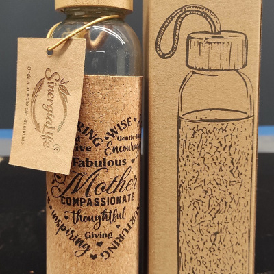 Garrafa de vidro com tampa e revestimento em cortiça, etiqueta Sinergialife e caixa de papelão com desenho da garrafa e texto BOTTLE