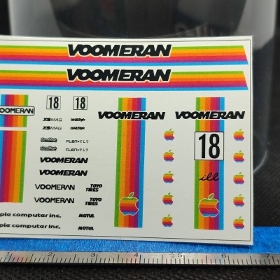 Folha de autocolantes coloridos com texto VOOMERAN e logos da Apple sobre fundo branco