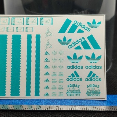 Folha de autocolantes Adidas azuis com régua abaixo