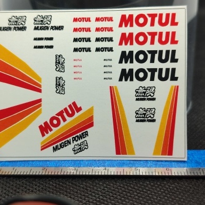 Folha de autocolantes com textos MUGEN POWER e MOTUL em várias cores e gráficos coloridos.