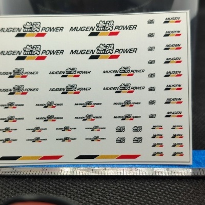 Folha branca com autocolantes MUGEN POWER e símbolos japoneses coloridos