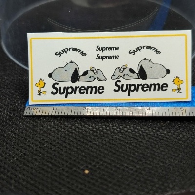 Autocolante com personagens Snoopy e Woodstock e texto Supreme