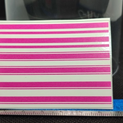 Régua em milímetros ao lado de uma carta com linhas horizontais cor de rosa