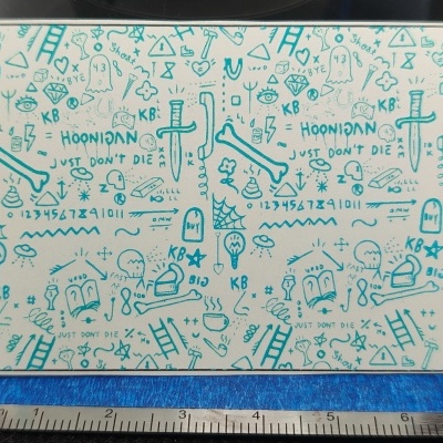 Quadro branco com desenhos e frases em marcador azul e régua abaixo