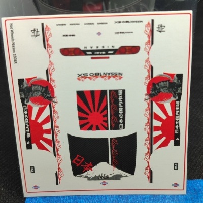 Folha de autocolantes para modelo de carro com gráficos em vermelho e preto e texto NISSAN 180SX.
