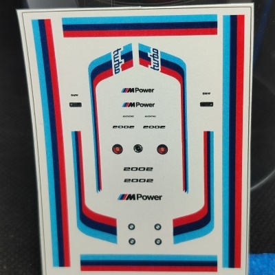 Autocolantes decorativos para modelo BMW com riscas coloridas e textos variados.