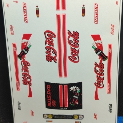 Adesivos decalques Coca-Cola e Datsun com texto e imagens de garrafas sobre fundo branco